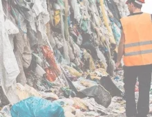 man looking at a pile of old textiles
