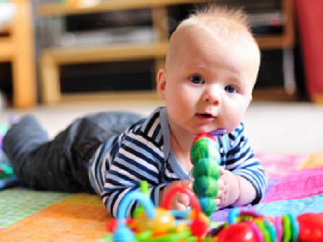 Baby on floor playing with toys